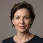 Профессиональный портрет уверенного бизнесмена в студийном освещении на нейтральном размытом фоне